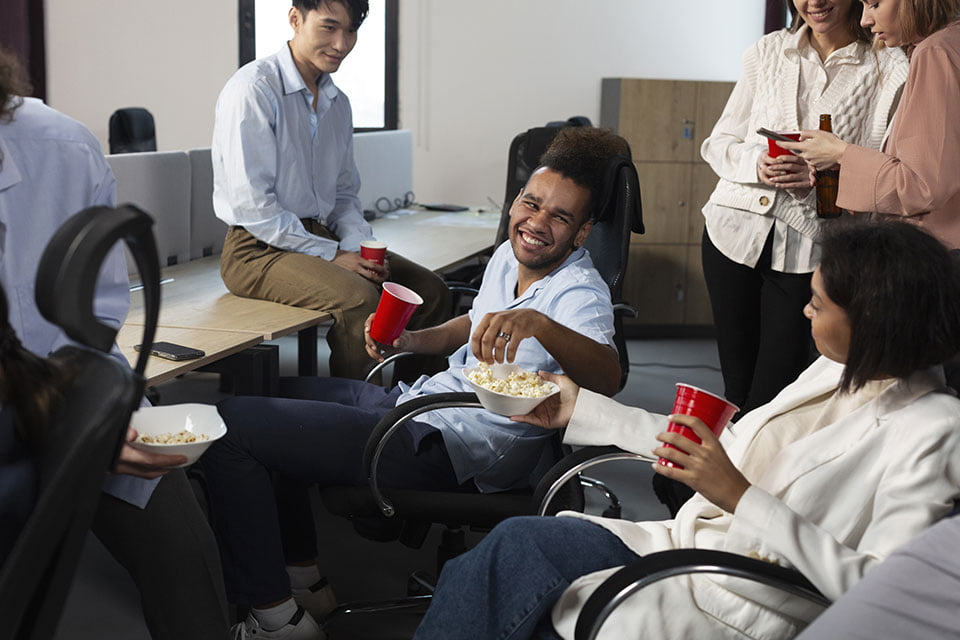 A group of people gathered around a table, enjoying popcorn together in a casual setting.